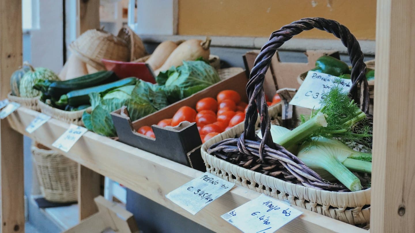 Market stall with fresh organic vegetables in baskets and crates.