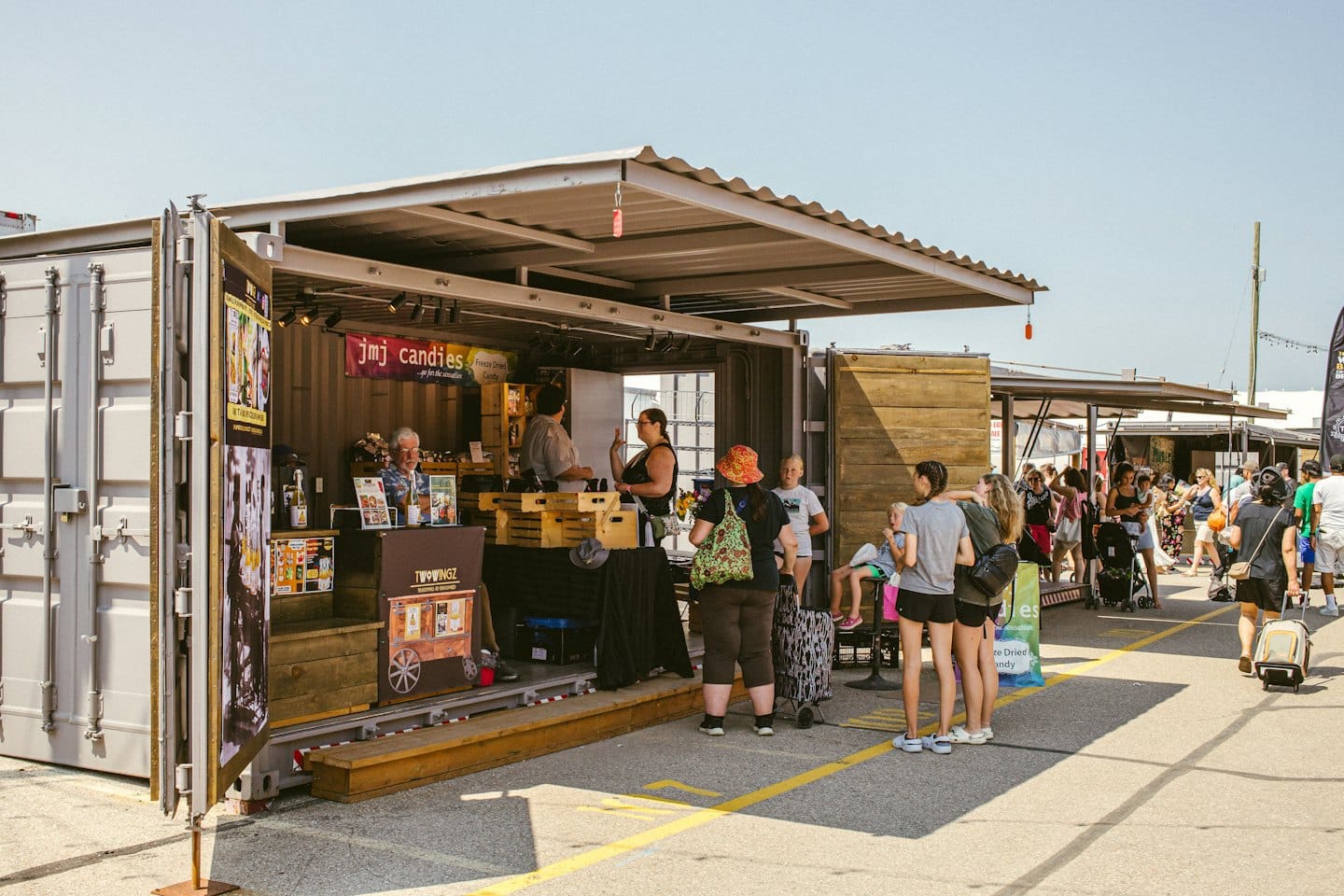 Shoppers browse stalls at an outdoor container market.